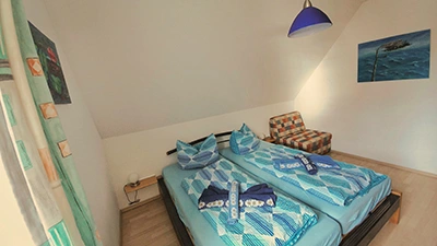 Schlafzimmer mit gemütlichem Doppelbett und Schlafsessel
